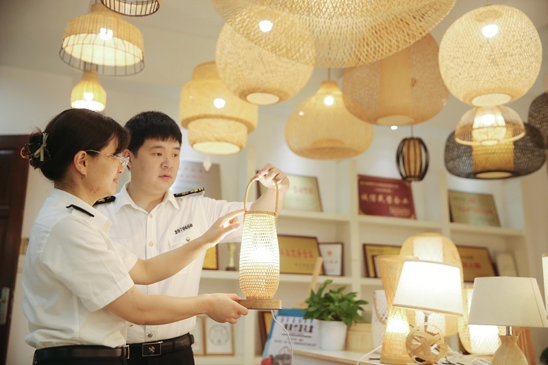 图为湖州海关关员在竹编灯具出口企业开展调研++谢颖摄.JPG